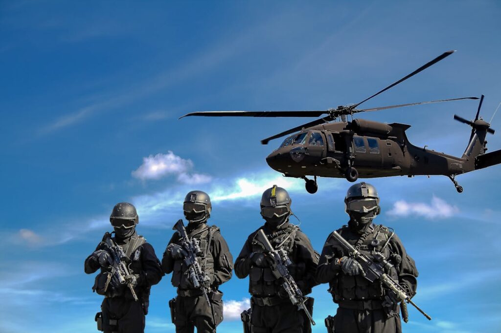 Four Soldiers Carrying Rifles Near Helicopter Under Blue Sky // Healthier Veterans Today
