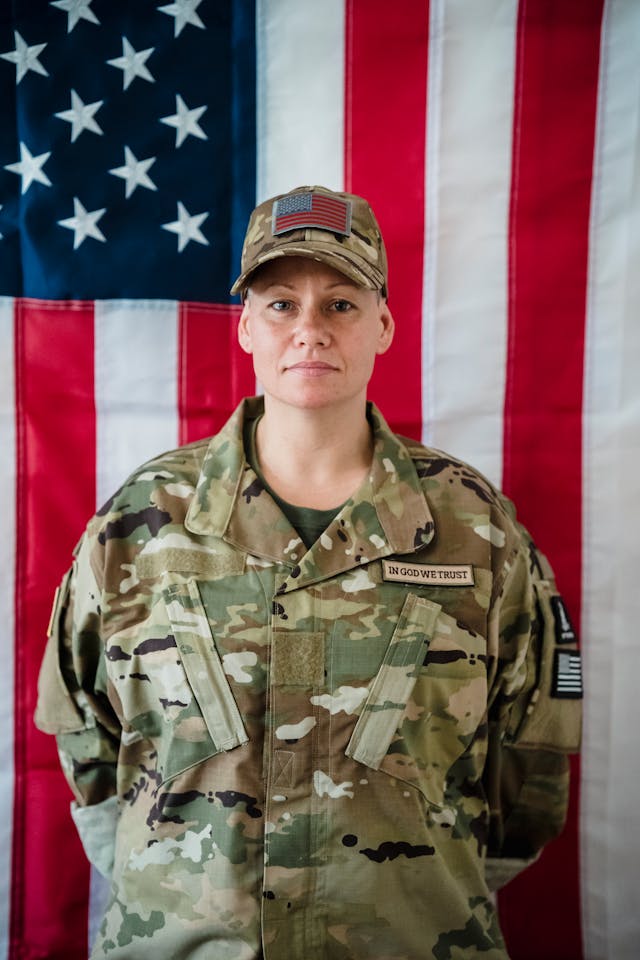 Woman Soldier in Uniform on American Flag Background // Healthier Veterans Today