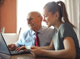 Service member, Young woman helping senior man with payment on Internet using laptop // Healthier Veterans Today
