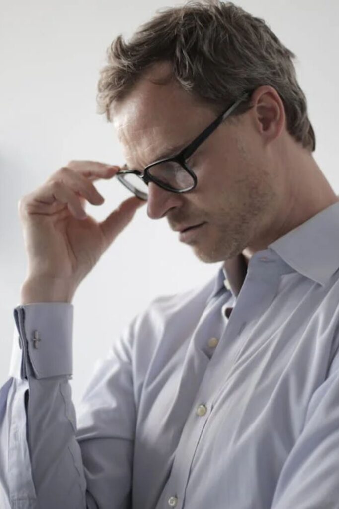 frustrated man holding his glasses, wearing a be shirt // Healthier Veterans Today