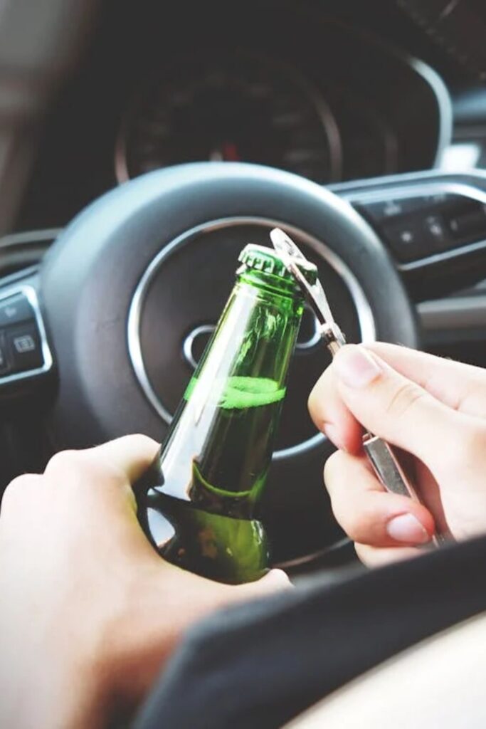 person opening botte of beer in a car // Healthier Veterans Today