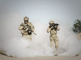 Types of PTSD, Men Holding Rifle While Walking Through Smoke Grenade // Healthier Veterans Today