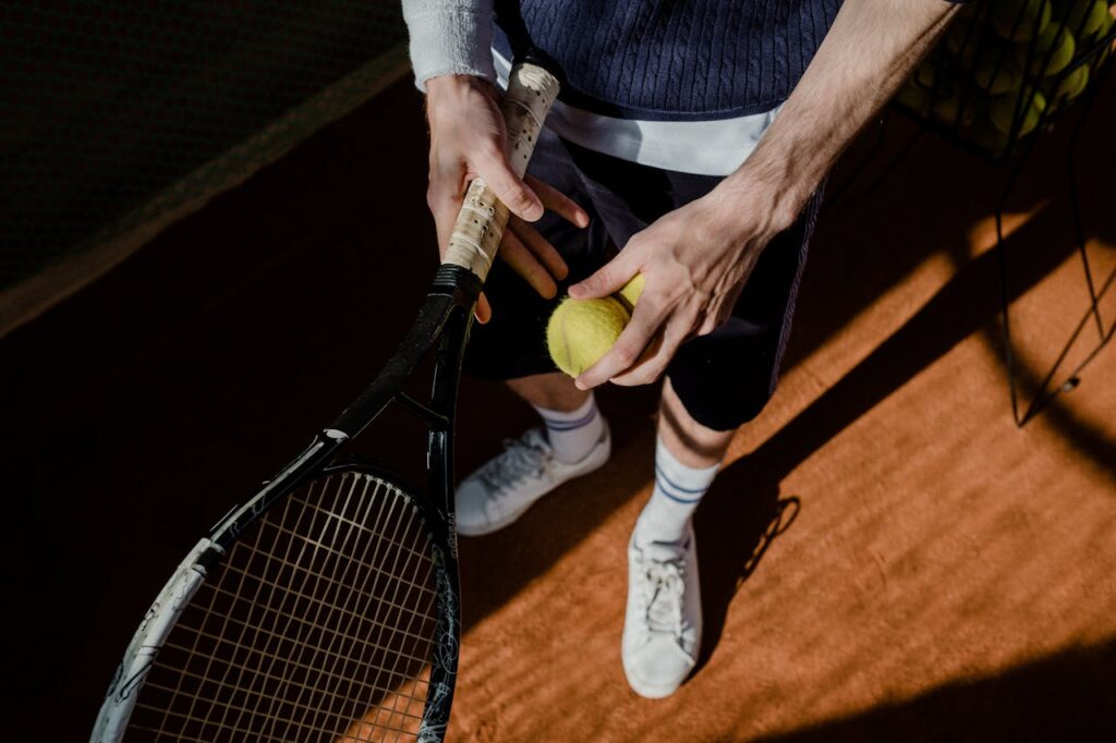 Person standing with tennis raquet and tennis ball // Healthier Veterans Today