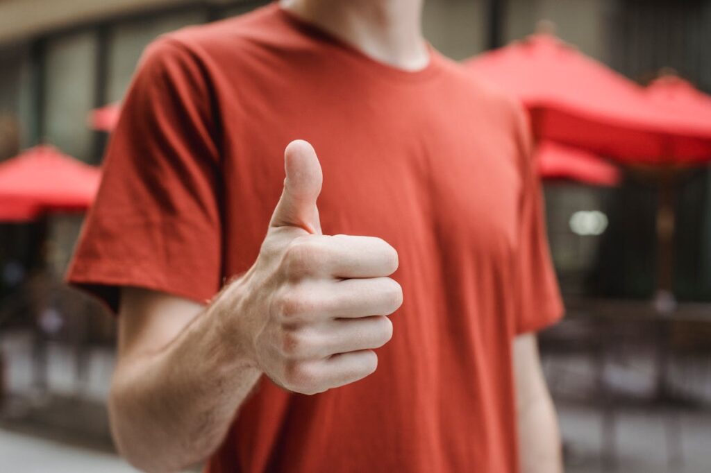 Unrecognizable man showing thumb up on city street // Healthier Veterans Today