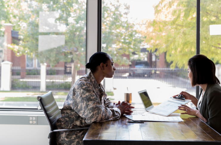Veteran meeting with a healthcare professional to discuss VA healthcare options and paperwork // Healthier Veterans Today